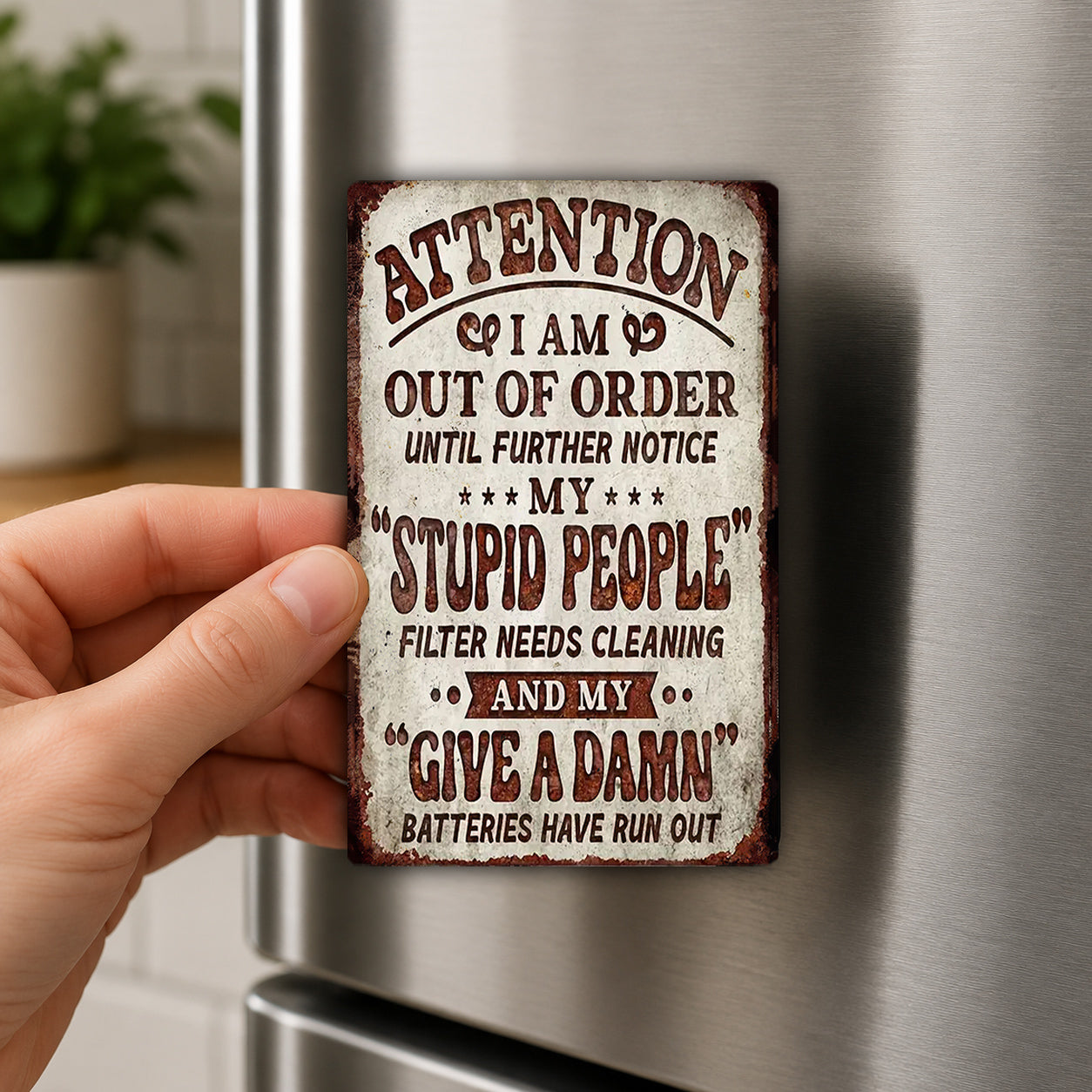 a person holding a metal sign with a humorous message on it.