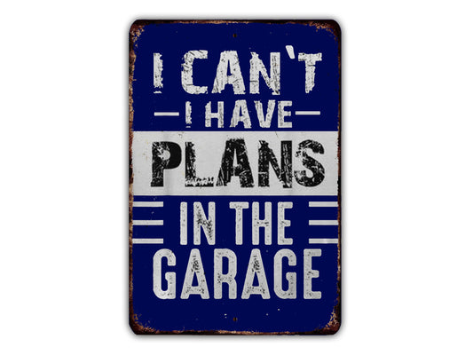 a sign with the text "I CAN'T HAVE PLANS IN THE GARAGE" in a blue and white color scheme.