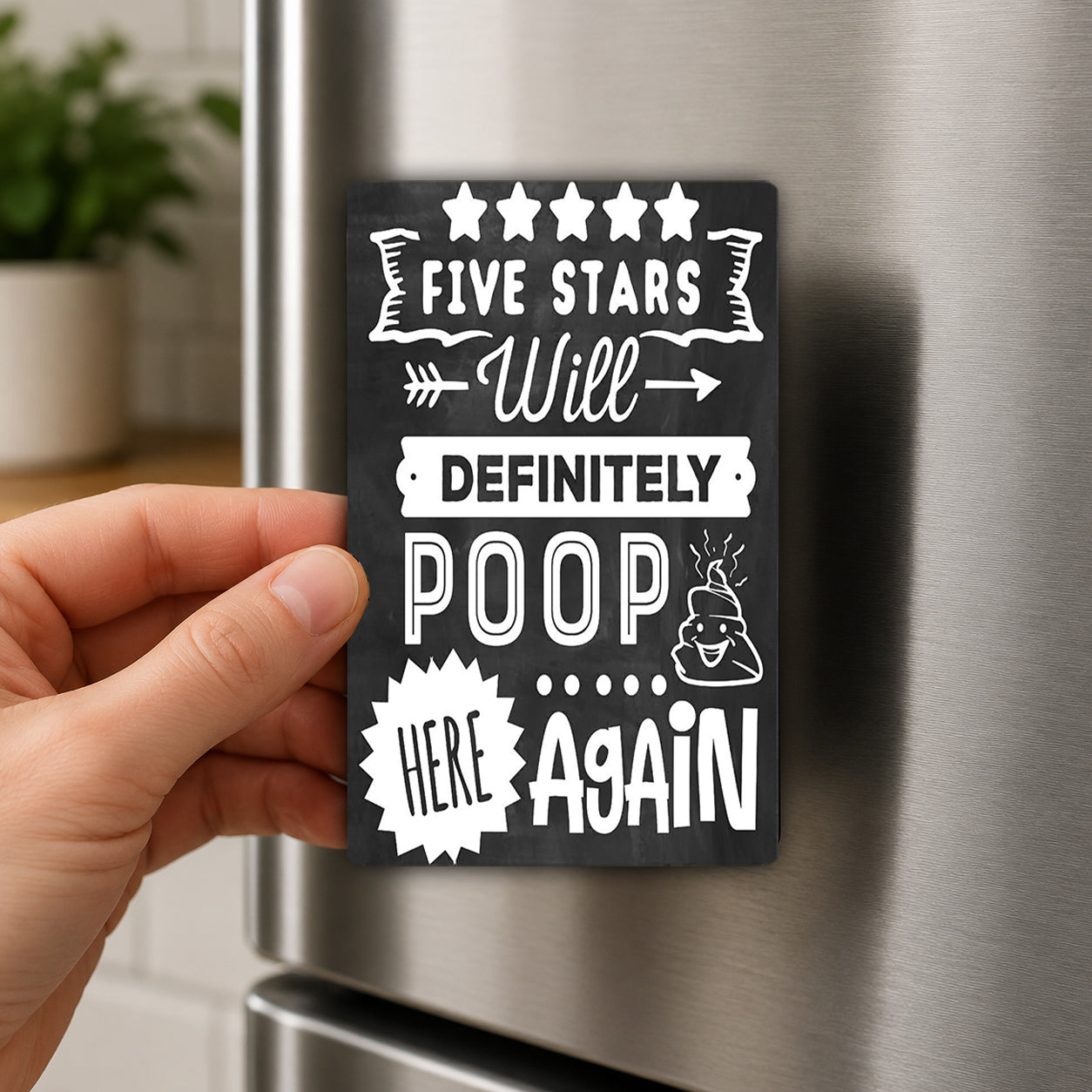 A hand holding a black and white magnet with text on it, which appears to be a humorous or playful message.