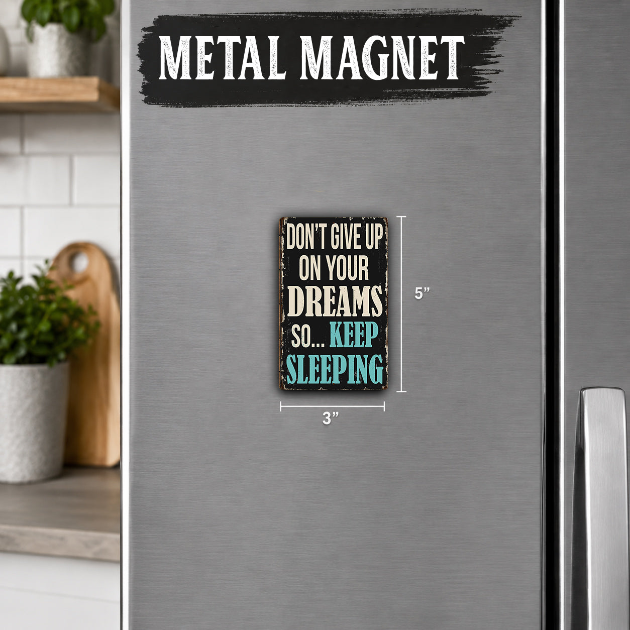 a refrigerator with a small metal magnet on it. The magnet has a message that says "Don't give up on your dreams so... keep sleeping".