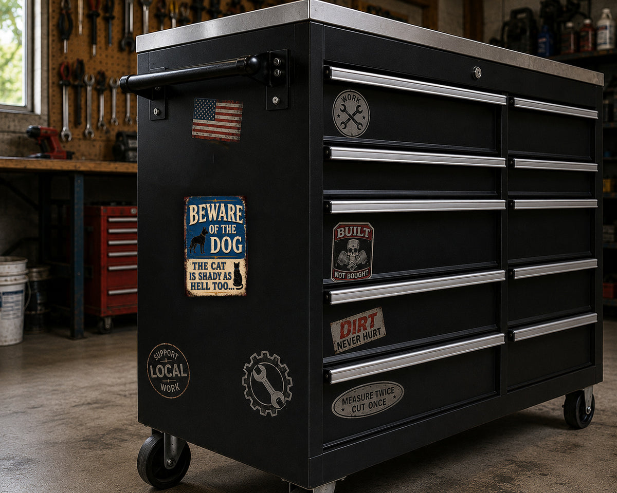 A black tool chest with various stickers and labels on it, placed in a workshop setting.