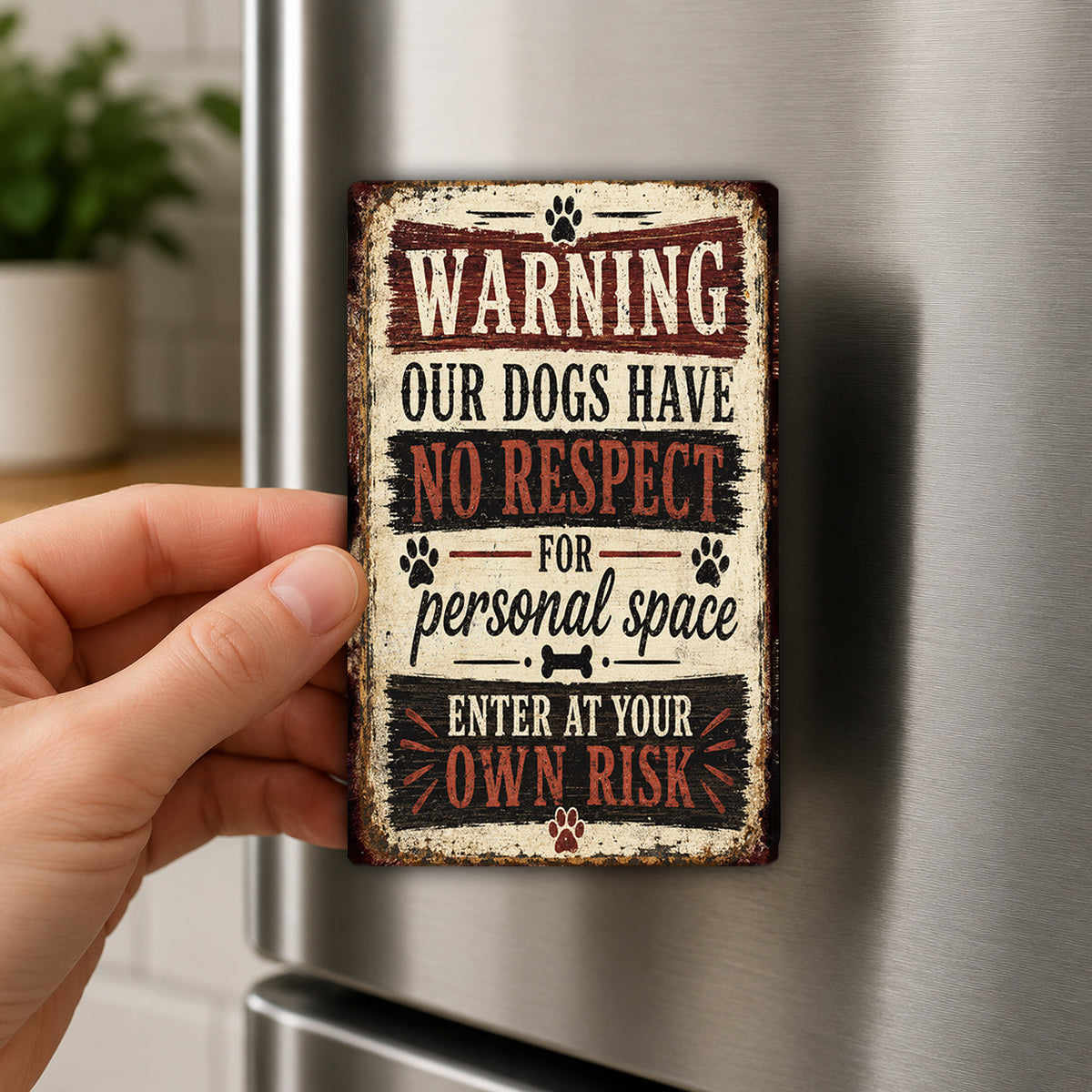 A person's hand is holding a metal sign with a warning message about dogs and personal space.