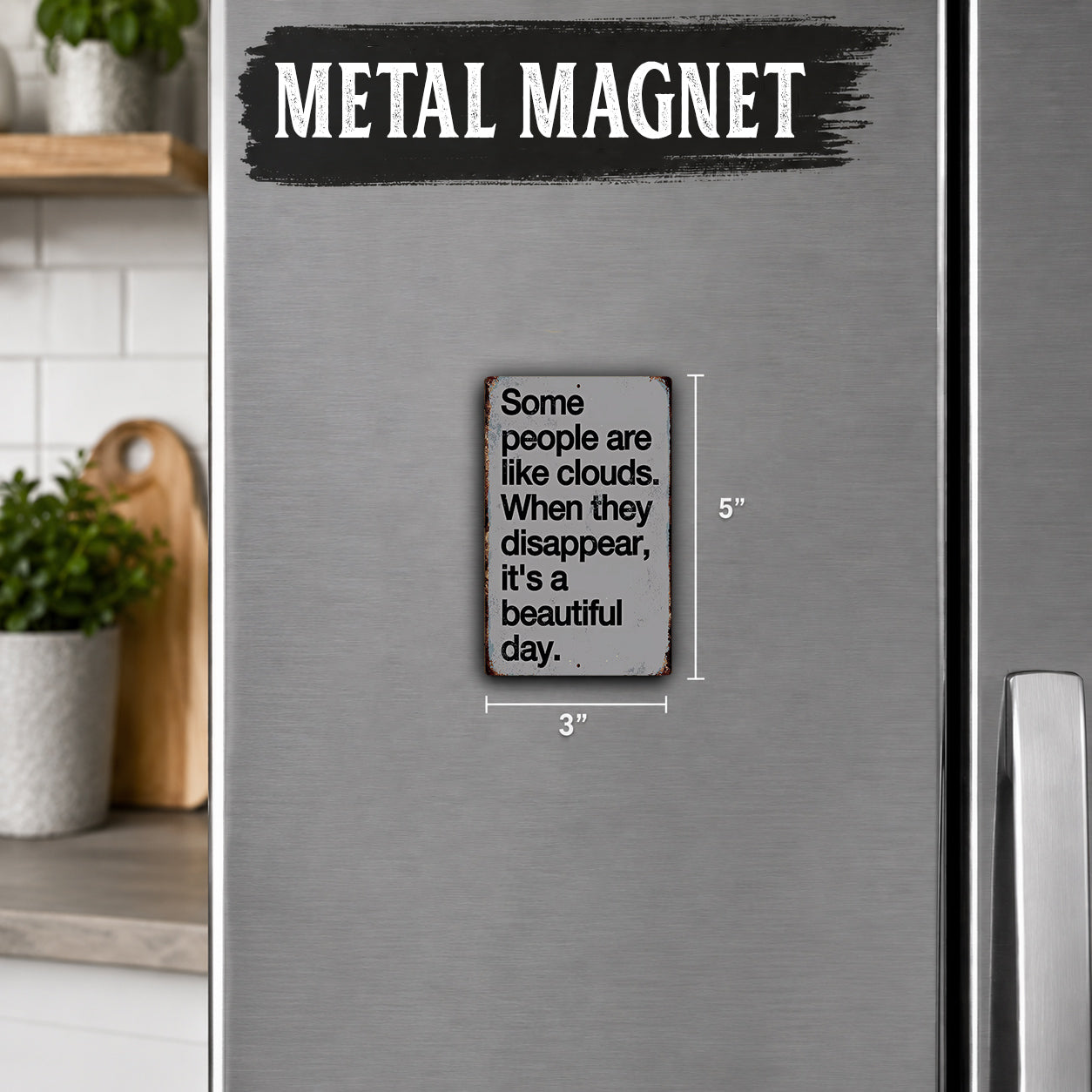 a small metal magnet with a humorous text on it, placed on a refrigerator.