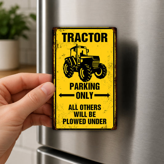 A person's hand is holding a yellow sign with a black tractor image and text, which appears to be a warning or restriction sign.
