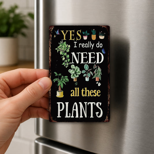 A person's hand is holding a small, decorative magnet with a message about plants.