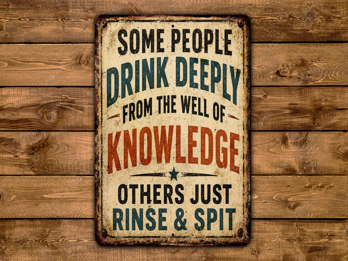 a vintage-style sign with the text "Some people drink deeply from the well of knowledge others just rinse & spit" displayed on a wooden background.
