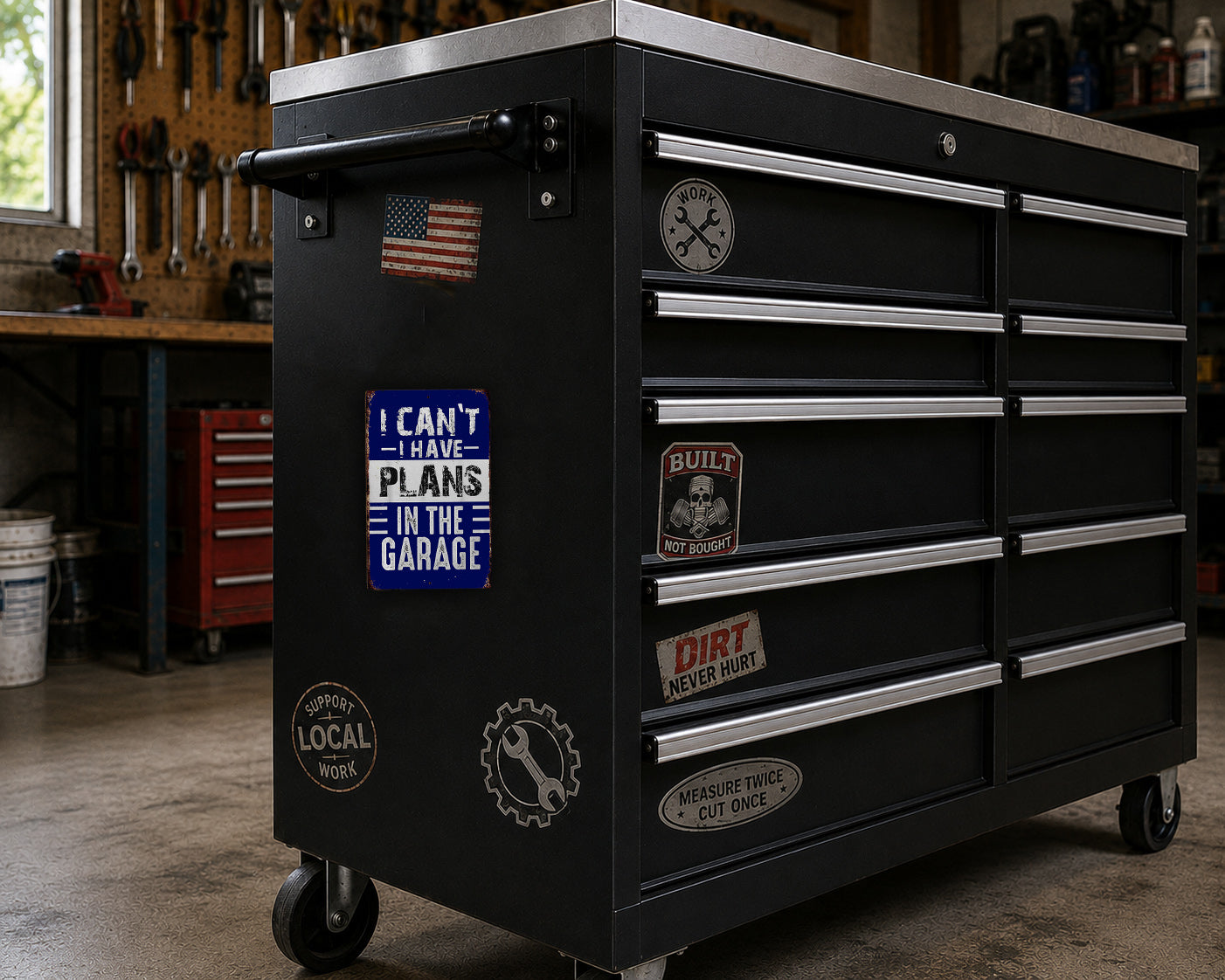 A black tool chest with various stickers and labels on it, placed in a workshop setting.