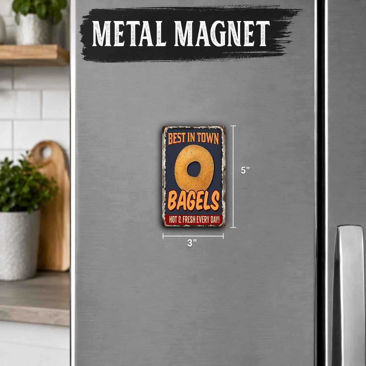 a metallic refrigerator with a metal magnet that says "BEST IN TOWN BAGELS HOT 2 FRESH EVERY DAY".