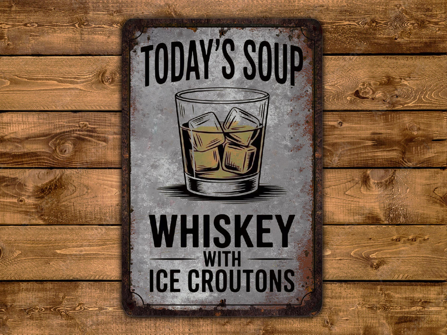 A metal sign with the text "Today's Soup Whiskey with Ice Croutons" and an illustration of a glass of whiskey with ice cubes.