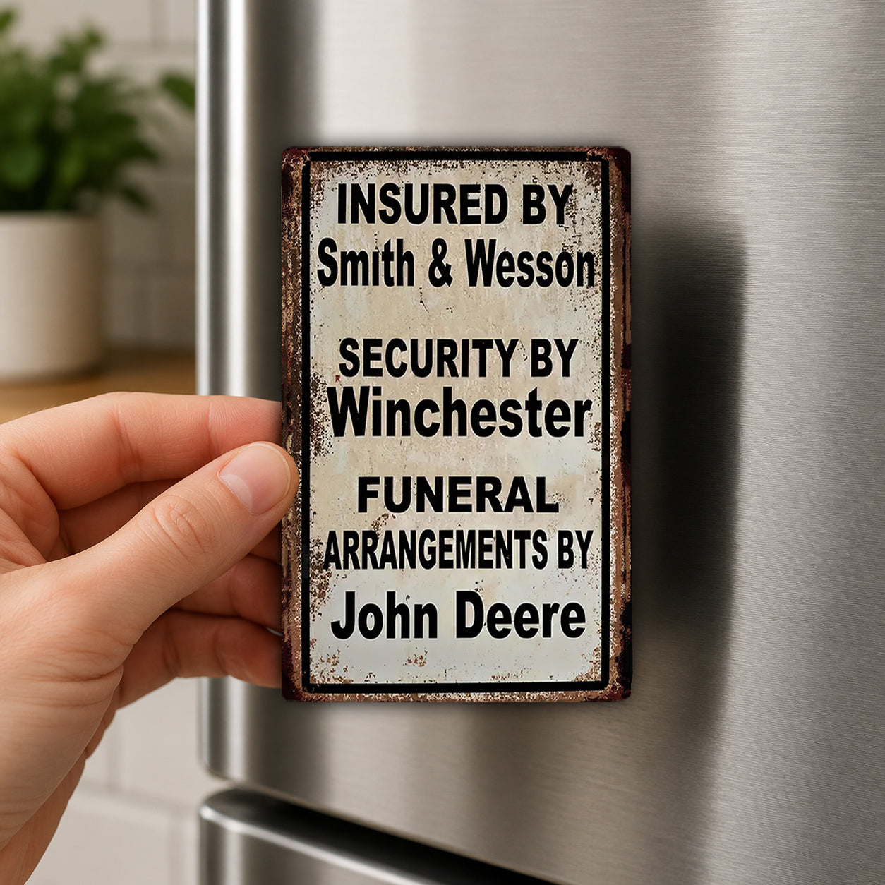 A person's hand is holding a metal sign with text on it, which appears to be a humorous or unconventional message about funeral arrangements.