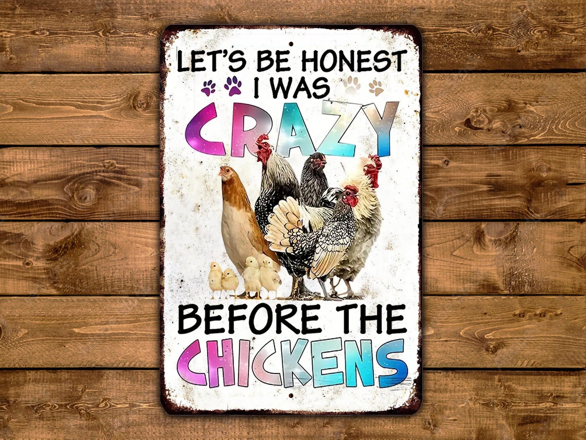 The image is a metal sign with a colorful illustration of chickens and text that reads "Let's be honest I was crazy before the chickens".