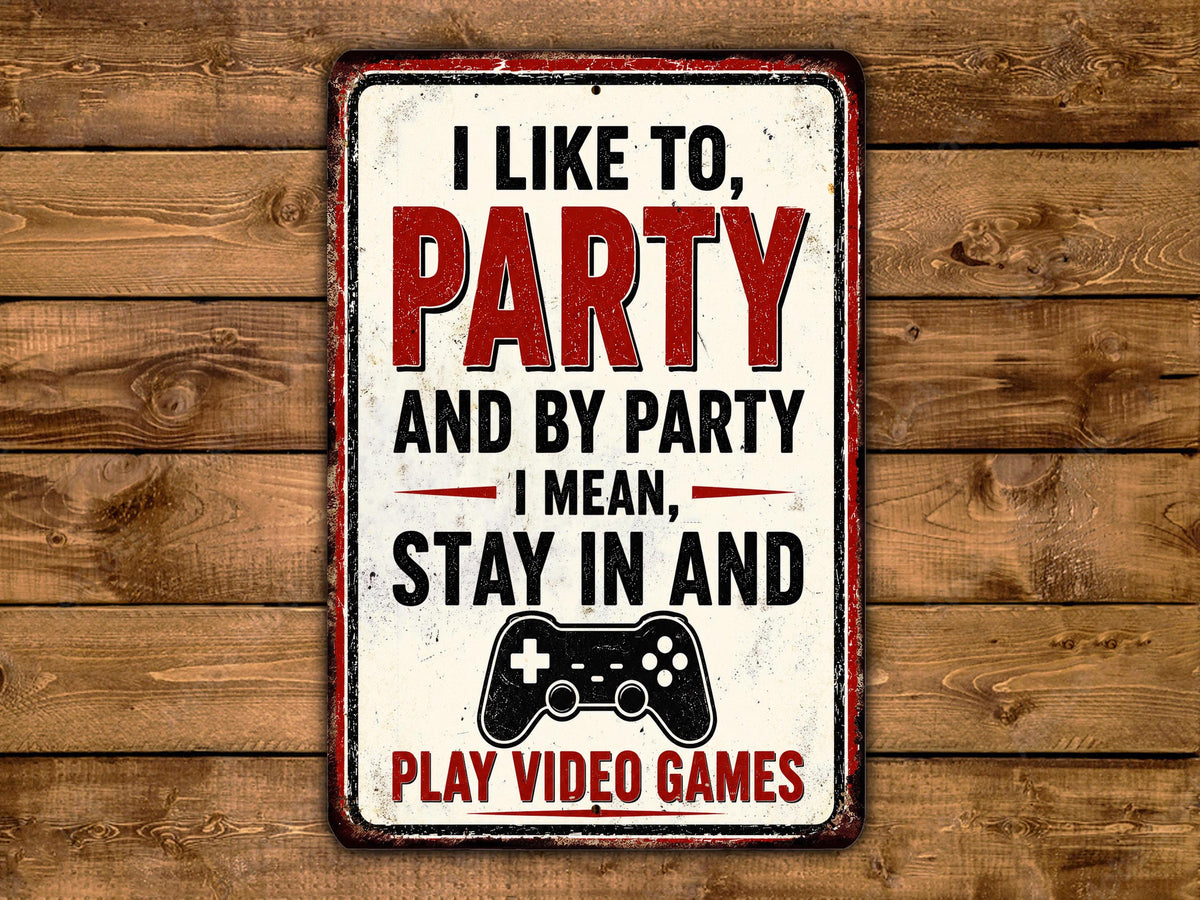 A metal sign with a red and white color scheme, placed on a wooden background. The sign displays a message that reads "I LIKE TO PARTY AND BY PARTY I MEAN, STAY IN AND PLAY VIDEO GAMES".