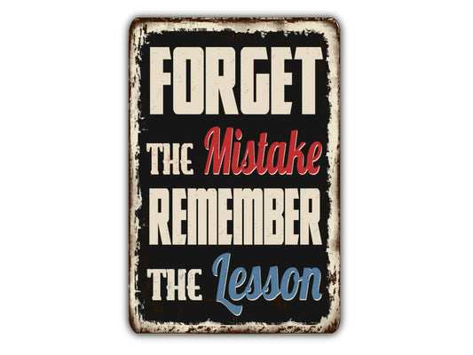 a sign that reads forget the mistake remember the lesson