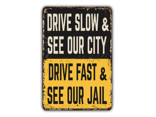 a sign that says drive slow and see our city drive fast and see our jail